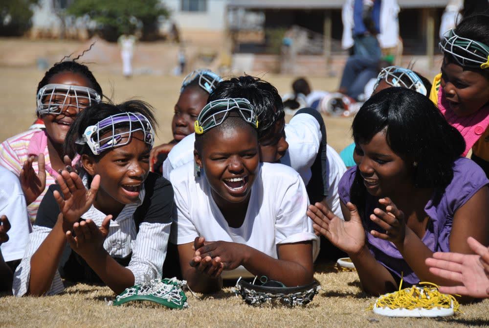 Young lacrosse players laughing together on the field in Vaalwater